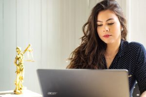 Woman lawyer on computer with lady justice